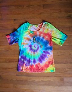 A tie dyed and patched one of a kind clothing item made by me. Size medium Multicolor Hippie Short Sleeve Top, Multicolor Short Sleeve Hippie Tops, Hippie Tie Dye Tops For Festivals, Multicolor Rainbow Print Tops For Festivals, Festival Multicolor Tops With Rainbow Print, Festival Multicolor Rainbow Print Tops, Tie Dye Rainbow Print Crew Neck Top, Tie Dye Crew Neck Top With Rainbow Print, Fitted Tie Dye Hippie Tops