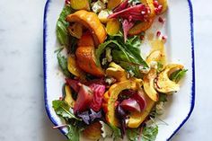 a white plate topped with lots of veggies and other food on top of a table