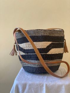 Black and white crossbody handbag great for your day out. It has lining and zipper. Dimensions A 59" strap lenght (26" high) B 13" C  9" D 13" E 8.5" Cross Body Handbag, Woven Bags, Basket Wall Decor, White Cross, African Baskets, White Crosses, Star Gift, Woven Bag, Baskets On Wall