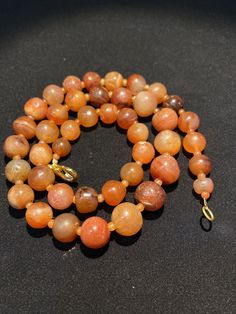 The orange color carnelian beads from my collections of ancient beads. The origin of this beads from Tibet although the carnelian agate can be found in Pakistan India Nepal and Afghanistan as well small agate beads used as counter beads best gift for the people who collect ancient beads and best for the people who study ancient history we provide fast and free shipping to our customers by which you can get the item by 7 maximum working days Orange Single Strand Spiritual Necklace, Orange Carnelian Polished Beads Necklace, Orange Agate Necklace With Polished Beads, Hand-strung Orange Necklace, Orange Carnelian Round Bead Jewelry, Antique Orange Jewelry With Round Beads, Antique Orange Beaded Jewelry, Single Strand Carnelian Necklace In Amber, Amber Carnelian Single Strand Necklace