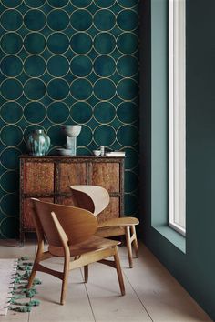 a chair sitting in front of a window next to a dresser and sideboard with vases on it