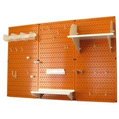 the pegboard wall has two shelves with hooks on it and one shelf is empty