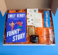 an open box containing books, wine glass and other items for a story book party