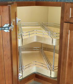 a corner view of a kitchen cabinet with stainless steel shelves and pull out shelving