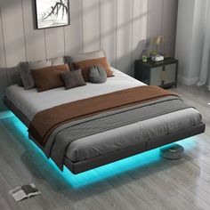 a bed with blue lights underneath it in a room that has wood floors and white walls