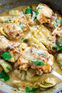 a pan filled with chicken and pasta covered in gravy, garnished with parsley