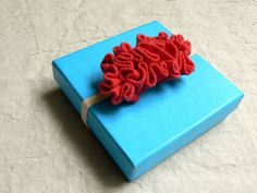 a blue box with a red object on top of it sitting on a white surface