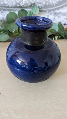 a blue vase sitting on top of a wooden table