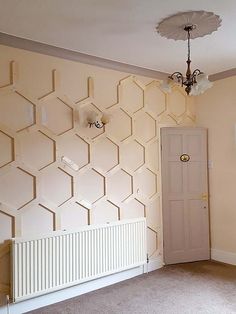 an empty room with a radiator, fan and light fixture on the wall