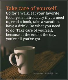 a coffee cup sitting on top of a wooden table next to a sign that says, take care of yourself