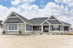 a large house with two car garages on the front and one story home in the back