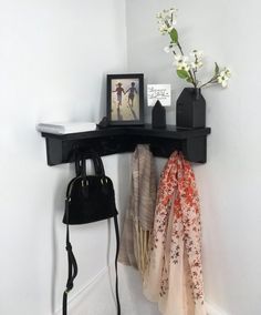 there is a black shelf with two pictures on it and a purse next to it