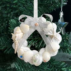 a christmas ornament with seashells hanging from it's side on a tree