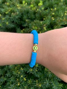 a person wearing a blue bracelet with a smiley face on it