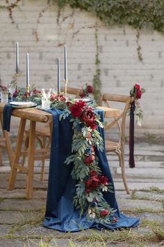 the table is set with candles, flowers and greenery for an elegant dinner party