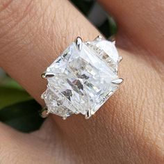 a woman's hand with a ring that has a large diamond on the side