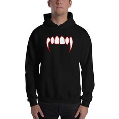 Nothing says Halloween like a good pair of Vampire Fangs. Display your love for Vampires with this Bloody Fangs Horror Design. Gothic Horror Occult Clothing. Everyone needs a cozy go-to hoodie to curl up in, so go for one that's soft, smooth, and stylish. It's the perfect choice for cooler evenings! * 50% pre-shrunk cotton, 50% polyester * Fabric weight: 8.0 oz/yd² (271.25 g/m²) * Air-jet spun yarn with a soft feel and reduced pilling * Double-lined hood with matching drawcord * Quarter-turned body to avoid crease down the middle * 1 × 1 athletic rib-knit cuffs and waistband with spandex * Front pouch pocket * Double-needle stitched collar, shoulders, armholes, cuffs, and hem This product is made especially for you as soon as you place an order, which is why it takes us a bit longer to del Punk Halloween Hoodie Sweatshirt, Hooded Tops For Halloween Streetwear, Edgy Black Halloween Sweatshirt, Black Hoodie For Halloween Cosplay, Edgy Long Sleeve Halloween Hoodie, Black Crew Neck Hoodie For Halloween, Black Halloween Cosplay Hoodie, Halloween Hoodie For Streetwear, Halloween Punk Hoodie Tops