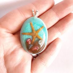 A real life starfish with real sand and seashells to decorate your neck this summer or for anytime! I prefer to work with mini items to use so the pendant is light, but the detail put in is still there. Made with resin to keep this keepsake and pendant durable and beautiful.  Update: Necklace chains now available. Free shipping in US! Any questions or suggestions message me. Handmade Oval Jewelry For Beach, Handmade Shell Starfish Jewelry, Handmade Starfish Shaped Shell Jewelry, Handmade Starfish Shell Jewelry, Handmade Starfish Shell Necklace, Starfish Shell Necklace As Gift, Starfish Shell Necklace For Gift, Handmade Starfish Shell As Gift, Starfish Shell Necklace Perfect For Gifts