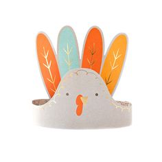 a paper turkey head on top of a white surface with orange and blue leaves around it