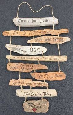 some wooden signs hanging on a black surface with writing and words written on them,