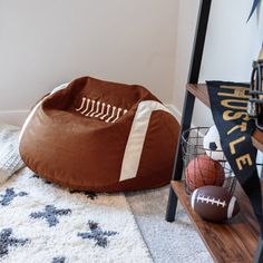 a football themed dog bed on the floor next to a shelf with balls and toys