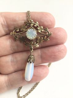 Vinyl Art Deco Downton Abby style opalescent teardrop necklace, faceted glass opalescent center stone within a floral wreath with a large teardrop opalescent glass teardrop, hangs on a twisted rope gold plated 18 inch chain Excellent preowned condition  Free shipping Vintage Teardrop Filigree Jewelry, Vintage Filigree Teardrop Jewelry, Vintage Opal Gemstone Jewelry, Antique Teardrop Cabochon Jewelry, Victorian Opal Oval Jewelry, Vintage Gold Opal Jewelry, Victorian Oval Opal Jewelry, Antique Gold Opal Jewelry, Victorian Teardrop Wedding Necklace