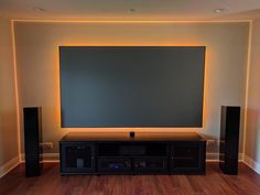 an entertainment center with speakers and a large screen