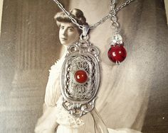 "Offering an exquisite vintage circa 1930s era genuine carnelian gemstone Edwardian/Art Deco 800 Silver marked filigree pendant necklace. Let me start by staying that photos don't come close to doing this treasure justice! This necklace will be as perfect with a pair of jeans and a tee as it will with a Bridal gown. The ornate lacy high quality dimensional sterling silver filigree open work pendant features a central bezel set round carnelian cabochon. I love the ornate design in the filigree wo Victorian Carnelian Jewelry For Formal Occasions, Vintage Red Carnelian Jewelry, Red Carnelian Vintage Jewelry, Vintage Red Gemstone Necklace, Red Carnelian Wedding Jewelry, Vintage Carnelian Jewelry For Wedding, Vintage Carnelian Jewelry For Weddings, Vintage Silver Carnelian Necklace, Vintage Silver Carnelian Necklaces