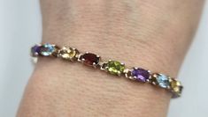 This is a beautiful sterling silver bracelet set with twenty 6mm by 4mm oval real gemstones. There are four garnets, four peridots, four amethyst, four aquamarines, and four citrines. The bracelet fits a 7 inch wrist and is stamped with 925 and China. Elegant Multicolor Gemstones For Formal Occasions, Oval Multicolor Jewelry For Formal Occasions, Classic Multicolor Bracelets For Formal Occasions, Classic Multicolor Bracelets For Formal Events, Oval Multi-stone Jewelry For Formal Occasions, Elegant Multicolor Gemstones For Anniversary, Classic Multicolor Gemstone Jewelry, Elegant Multicolor Oval Jewelry, Modern Multicolor Jewelry With Stones