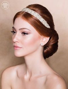 a woman with red hair wearing a bridal headband and diamond jewelry on her forehead