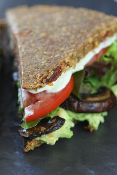 a sandwich with lettuce, tomato and mushrooms on it