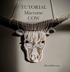 a cow's head hanging on the wall next to a sign that reads, tutor macrame cow