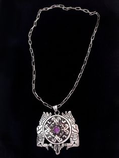 "Vintage Mexican pendant with amethyst, on a handmade chain, circa 1930s. The pendant measures 2 3/4\" long, 2 1/2\" wide, and has a design of two Aztec or Inca warrior figures on either side of a shield, with a small amethyst stone in the middle. Classic vintage Taxco design. It is on a 20\" long beautifully textured handmade chain with a hook clasp. The back of the pendant is marked \"Sterling\" and \"Hecho en Mexico\" with unknown initials. We ship with USPS, insured for the full value of the Collectible Amethyst Jewelry, Purple Necklace With Large Round Pendant, Hand Forged Amethyst Pendant Necklace, Collectible Amethyst Purple Necklace, Collectible Amethyst Necklace In Purple, Collectible Purple Amethyst Necklace, Purple Sterling Silver Necklace With Large Pendant, Purple Pendant Necklace With Large Pendant, Purple Necklace With Large Pendant