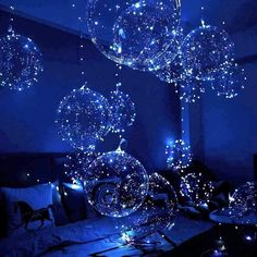 some lights that are hanging from the ceiling above a bed in a room with blue walls