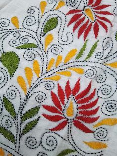 an embroidered table cloth with colorful flowers on it