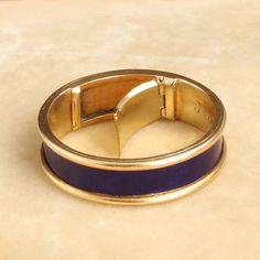 a gold and blue ring sitting on top of a table