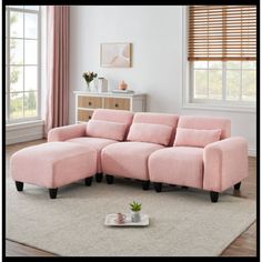 a living room with a pink sectional couch and coffee table on the floor in front of it