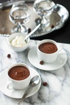 two cups of hot chocolate on a marble table