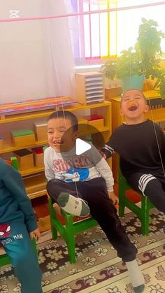 three children are sitting in chairs with masks on their heads and one child is holding a string