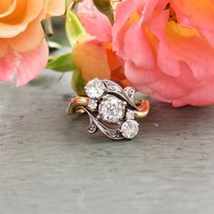 two diamond rings sitting next to pink flowers