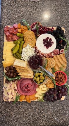 a platter filled with cheese, crackers, olives, and other foods