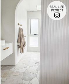 a bathroom with white walls and stone flooring is featured in the real life project