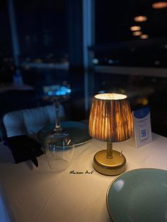 a lamp sitting on top of a table next to a plate