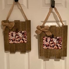 two wooden frames with bows hang on the wall next to each other in front of a door