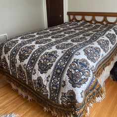 a bed sitting on top of a hard wood floor next to a wooden headboard