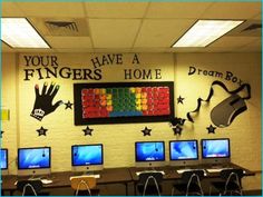 a classroom with computers and laptops on the desk in front of a sign that says your fingers have a home