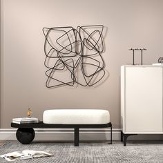 a living room with a white couch and black coffee table in front of a wall sculpture