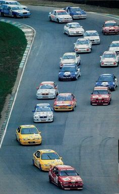 a group of cars driving down a race track