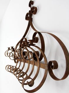 a metal wall hanging on the side of a white wall with circles and swirls