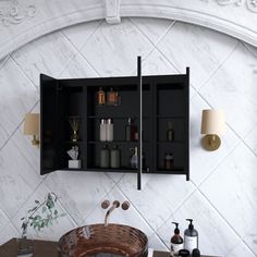 a bathroom sink sitting under a mirror next to a wooden cabinet with bottles on it